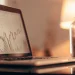 Bitcoin price chart on a laptop with coins.